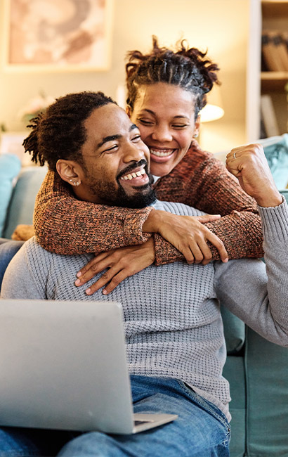 portrait of young happy couple on their laptop pay off your debt